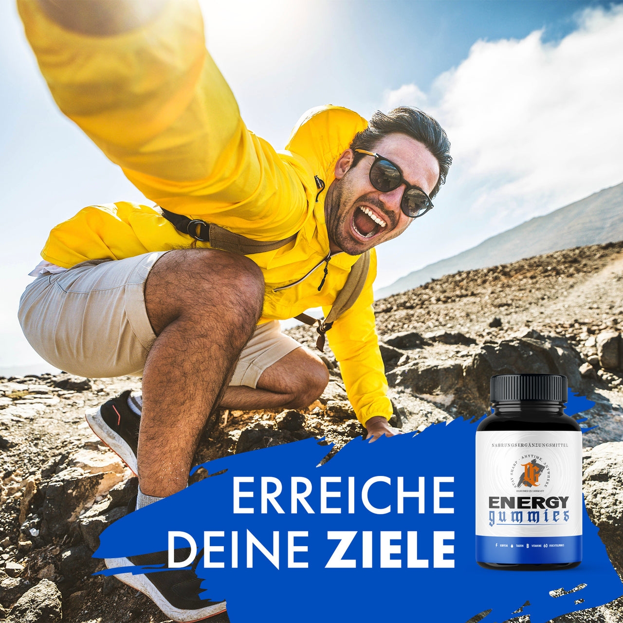OG-Energy-Gummies-Dose neben Mann in gelber Jacke auf felsigem Gelände mit Text „Erreiche deine Ziele“