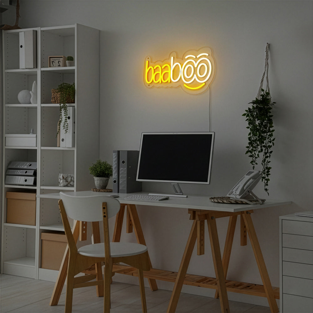 Arbeitsplatz mit Schreibtisch, Computer und Regal, darüber baaboo LED Leuchtschild mit Smiley an Wand