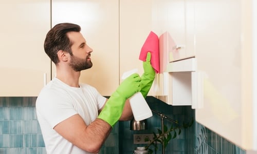 küchenfronten reinigen küchenschränke hängeschränke mann putzmittel gummihandschuhe lappen tuch